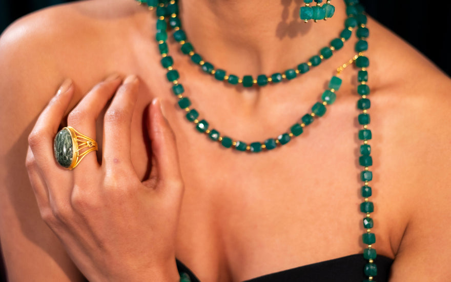 Women wearing gemstone green jewelry necklace, ring, bracelet