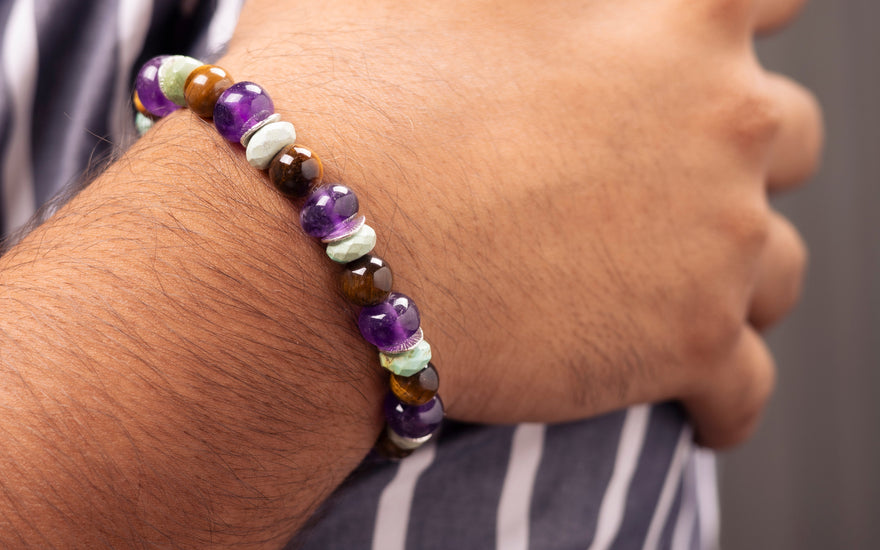 Men hand on shoulder showing gemstone bracelets
