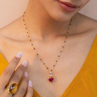 a beautiful women in yellow dress wearing pink ruby stone chain mangalsutra from stone story brand