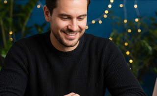 Man in black t-shirt wearing Scorpio stone bracelet and smiling with his inner achievements