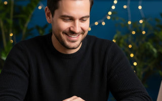 Man in black t-shirt wearing Scorpio stone bracelet and smiling with his inner achievements