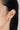 A model wearing round 18k Gold plated 925 sterling silver stud earrings featuring bezel-set clear quartz gemstones and textured edge detailing.