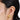 A model wearing Heart-shaped stud earrings featuring bezel-set clear quartz gemstones in 925 sterling silver with 18K gold matt plating 