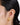 A model wearing Heart-shaped stud earrings featuring bezel-set clear quartz gemstones in 925 sterling silver with 18K gold matt plating 