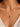 A close-up of a model's neck wearing a delicate 925 sterling silver 18k gold plated chain necklace with a small bow-shaped pendant featuring a central round pink gemstone.