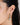 a model wearing Hexagon drop hoop earrings featuring bezel-set peridot gemstones in 925 sterling silver with rhodium plating