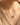 A close-up of a person wearing a delicate 925 sterling silver necklace with a bow-shaped pendant featuring a small pink gemstone at the top, paired with a beige knit sweater