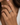 A close-up of a woman's hand wearing stack of three slim eternity rings. The rings feature alternating rows of pave band ring made in 925 sterling silver finished in 18K Gold, Rose Gold and rhodium
