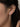 A close-up of a model's ear wearing 925 sterling silver rhodium plated drop earring with five clear round-cut stones.