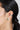 Model wearing a CZ ear cuff in rhodium plated 925 sterling silver featuring a bezel-set green cubic zirconia stone.